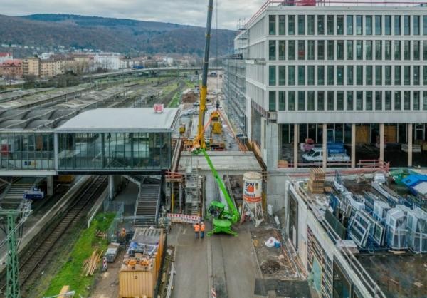 Die neue Fußgängerbrücke zwischen Hauptbahnhof und Europaplatz wird gebaut: 24 tonnenschwere Elemente wurden dafür mittels eines Autokrans durch die Luft transportiert und in ihre Position montiert. (Foto: Tobias Dittmer) Der neue Verbindungsteg zwischen dem Heidelberger Hauptbahnhof und dem Europaplatz.