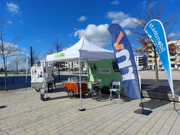 Ein Infostand mit Fahnen und einem Fahrrad