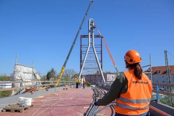 Eine Person blickt zu einem Pylon auf einer Brücke