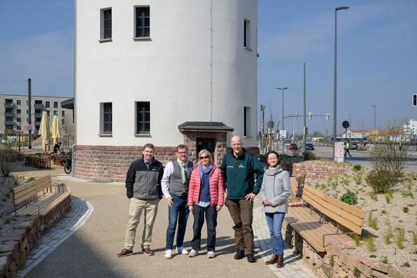 Die neu gestaltete Platzfläche am Wasserturm in der Bahnstadt ist fertig. Über den neuen Aufenthaltsort im Stadtteil freuen sich (von links) Manuel Ballarini (Landschafts- und Forstamt), Bürgermeister Raoul Schmidt-Lamontain, Monika Kissel-Kublik (Landschafts- und Forstamt), Dr. Ernst Baader (Leiter Landschafts- und Forstamt) und Kerstin Maixner (Geschäftsstelle Bahnstadt). (Foto: Philipp Rothe) Ein Gruppenfoto mit fünf Personen auf einem Außengelände vom Heidelberger Wasserturm.