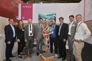 Eine Gruppe von Personen posieren einem Messestand