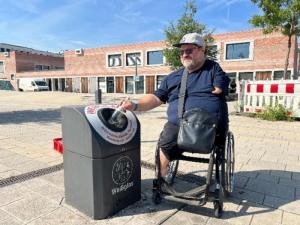 Ein Rollstuhlfahrer an einem Mülleimer