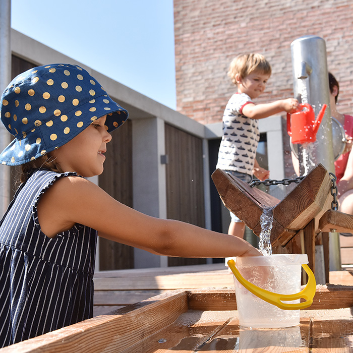 Kinder spielen im Innenhof der Kita Gadamerplatz auf dem Wasserspielplatz. (Foto: Buck)