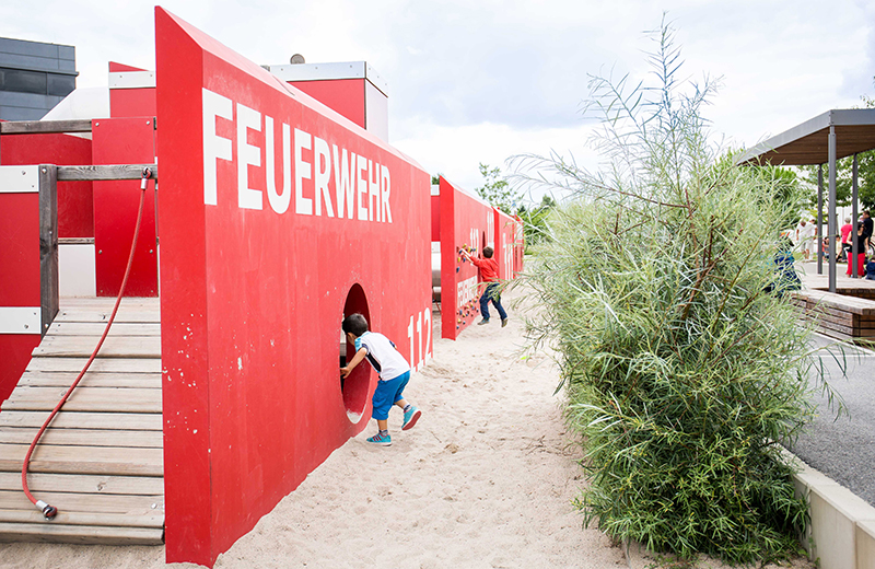 Dieses soll als Motto der Gestaltung des Spielraumes zu Grunde liegen und auch die Topografie, Vegetation oder Ausstattung berücksichtigen. Weiterhin soll ein vielfältiges und kreatives Spielangebot dargeboten werden. (Foto: Spielende Kinder auf dem Themenspielplatz "Theater" der in allen Spielelementen Theatermasken aufweist (Foto: Settelune Photography) Dieses soll als Motto der Gestaltung des Spielraumes zu Grunde liegen und auch die Topografie, Vegetation oder Ausstattung berücksichtigen. Weiterhin soll ein vielfältiges und kreatives Spielangebot dargeboten werden. (Foto: Spielende Kinder auf dem Themenspielplatz "Theater" der in allen Spielelementen Theatermasken aufweist (Foto: Settelune Photography)